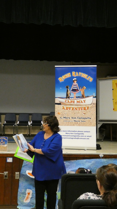 Mary Ann Castagnetta holding a book reading
